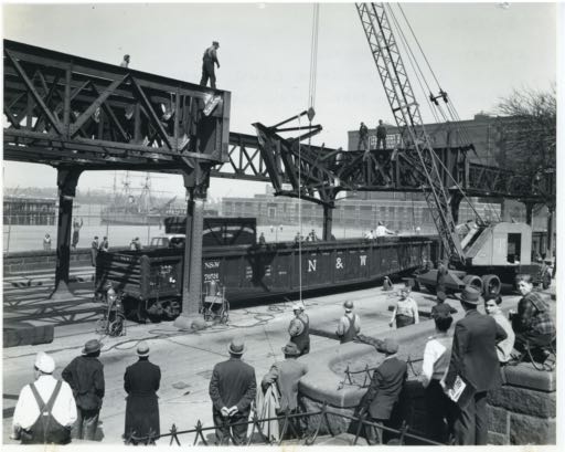 Dismantling the El tracks on Commercial Street, looking toward the right corner of the baseball field closest to our building. The USS Constitution is visible in the background.